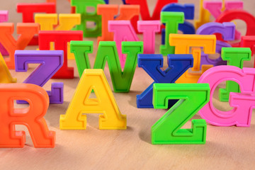 Plastic colorful letters close up on a wooden background