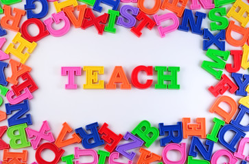 Teach written by plastic colorful letters on a white