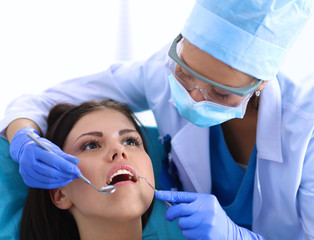 Woman dentist working at her patient&amp;amp;#39;s teeth
