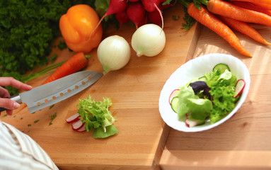 Young woman cutting vegetables in the kitchen