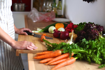 Young woman cutting vegetables in the kitchen