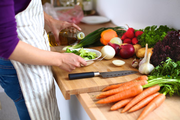 Young woman cutting vegetables in the kitchen