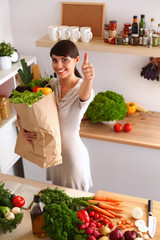 Young woman holding grocery shopping bag with vegetables