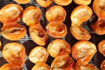 Drying apricots in direct sunlight in a rural environment.