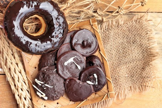 Chocolate donut of delicious on wood background.