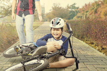 Naklejka premium Sad child gets accident with his bike