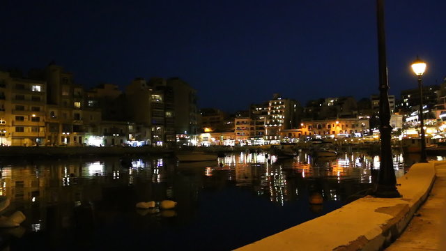 Malta island popular tourist town of St Julian and Spinola bay night light reflections