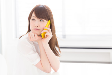 Fototapeta premium 部屋で電話をする女性