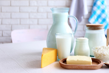 Dairy products on wooden table, on brick wall background