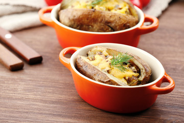 Baked potatoes with cheese and mushrooms on table close up