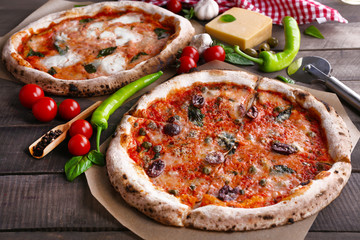 Delicious pizzas on wooden table, closeup