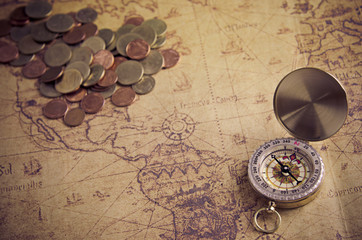 Fototapeta na wymiar Vintage compass and coins on old map