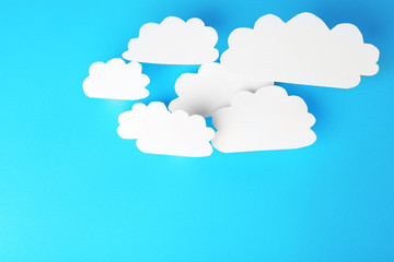 White paper clouds on blue background. Cloud computing concept.
