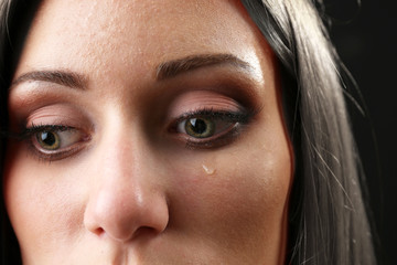 Face of young woman with tear drop close up