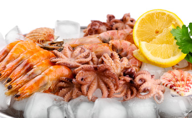 Seafood with lemon and ice on metal tray close up