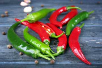 Hot peppers with spices on wooden table close up