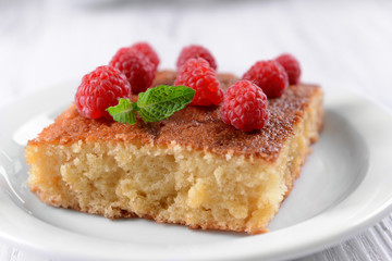 Fresh pie with raspberry in white plate on wooden table, closeup