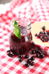 Jar of gooseberry jam on wooden table close-up