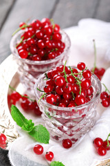 Fresh red currants in glasses on table close up