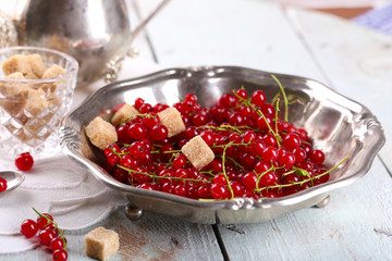 Fresh red currants with sugar on table close up