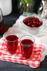 Sweet homemade cherry juice on table, on color background