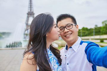 Beautiful Asian couple taking selfie in Paris