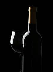 Bottle and glass of wine isolated on black
