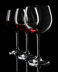 Naklejka na ściany i meble Glasses of wine isolated on black
