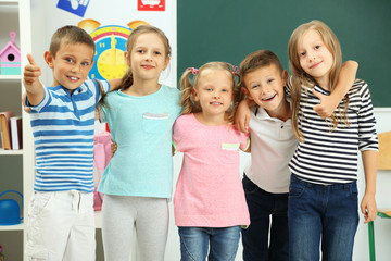 Portrait of happy classmates looking at camera in classroom