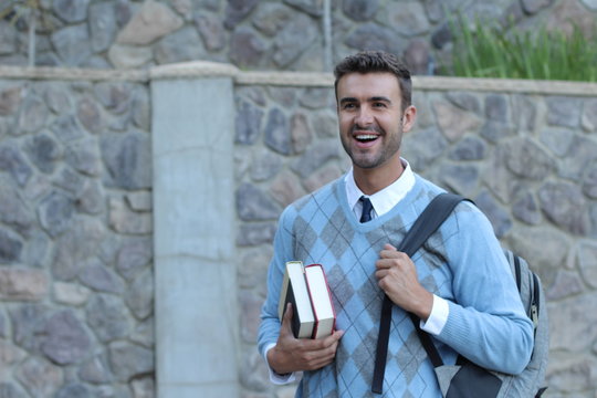 Happy handsome male student smiling - isolated at classic university entrance