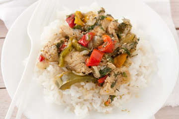 chicken or pork with peppers and herbs and spices over rice