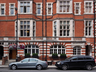 Fototapeta na wymiar London, apartment building with parked cars in Mayfair