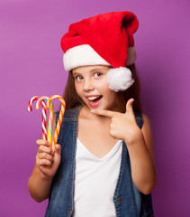 girl in red Santas hat with candy