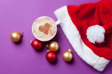 Obraz na płótnie Canvas Cup of coffee with heart shape near Santas hat