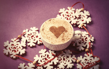 Obraz na płótnie Canvas Cup of coffee with heart shape and snowflakes