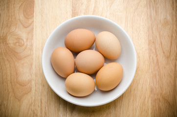 Fresh eggs in the white bowl on wooden background,food ingredient