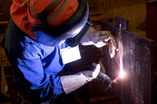 Worker is welding on the steel plate