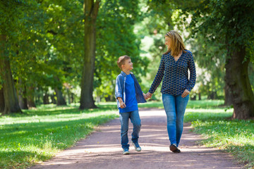 young woman with son walking through avenue