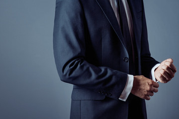 man in suit on a grey background, hands closeup