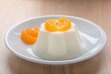 Pudding milk with orange topping in white dish