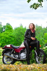 Naklejka na ściany i meble Biker girl in leather jacket on a motorcycle