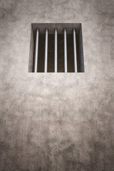 3 D render of prison wall with jail bars in the window.
