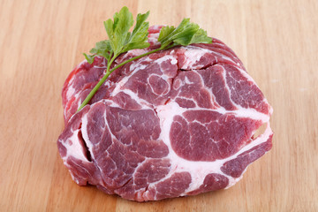 Fresh crude pork neck meat steak on wood background