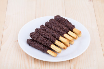 snack food biscuit stick chocolate coated on wood blackground