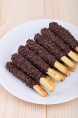 snack food biscuit stick chocolate coated on wood blackground