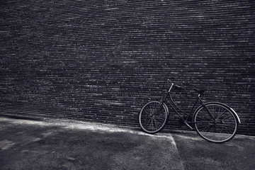 Selbstklebende Fototapeten Fahrrad Classic vintage hipster bicycle leaning against the street wall  © Bits and Splits