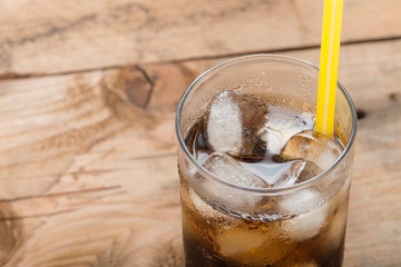 Soft drinks, Cola glass with ice cubes on a wood background.