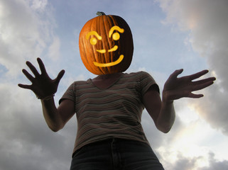 Scary Pumpkin headed woman silhouetted against the sky