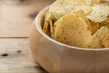 Potato chips in a wooden bowls, close-up