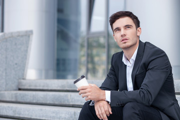 Handsome young man is resting near his office